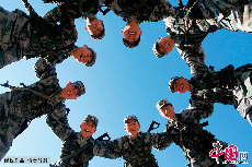 射击训练结束后，面对取得的骄人成绩，战士们围绕在一起露出了开心的笑容，齐声高喊：“加油，兄弟！”。中国网图片库  魏建顺/摄