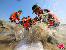 2013年10月12日，浙江省嘉興市，武警官兵正在勤民村受災嚴重的地方修築堤壩防止河水倒灌。 郭廣傑/CFP