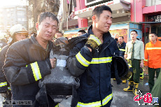 北京，消防中隊的隊員將殉職的消防員使用的氧氣瓶抬出火場。圖片來源：CFP