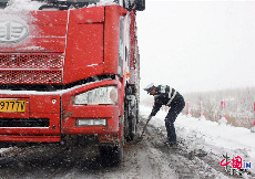 10月13日，在301国道内蒙古牙克石市境内，交警在雪中疏导交通。 中国网图片库 王伟/摄
