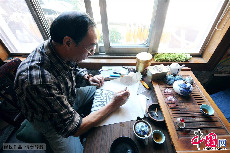 起稿也叫做画灰稿，用柳枝炭条代替画笔，在纸上勾画轮廓成灰稿。中国网图片库 王海滨/摄