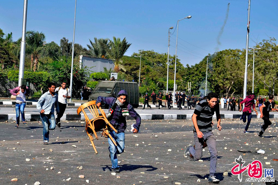 当地时间2013年10月20日，埃及开罗，3000名艾资哈尔大学学生举行反军方示威，封锁街道，与防暴警察发生冲突，警方采用催泪弹驱散示威群众。图片来源：cfp