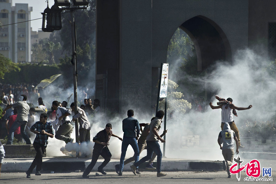 当地时间2013年10月20日，埃及开罗，3000名艾资哈尔大学学生举行反军方示威，封锁街道，与防暴警察发生冲突，警方采用催泪弹驱散示威群众。图片来源：cfp