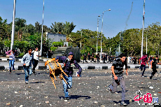 當地時間2013年10月20日，埃及開羅，3000名艾資哈爾大學學生舉行反軍方示威，封鎖街道，與防暴警察發生衝突，警方採用催淚彈驅散示威群眾。圖片來源：cfp
