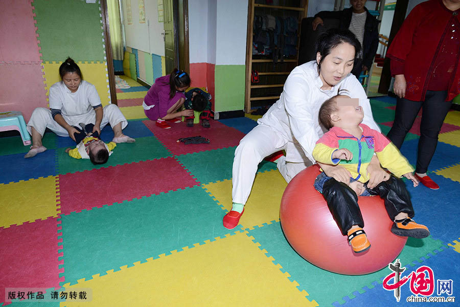 李艷在為腦癱兒童做康復訓練。中國網圖片庫 周會/攝 