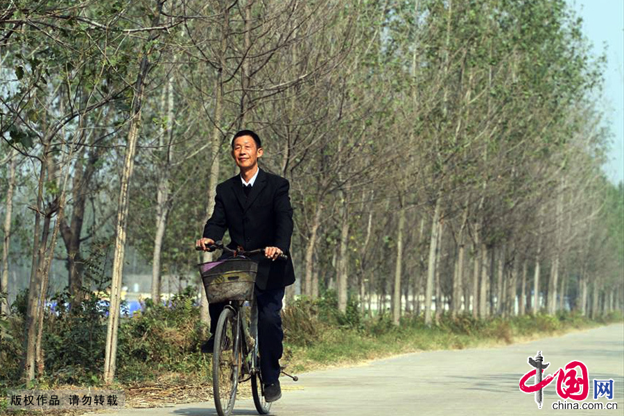 在刘桥小学上完音乐课后刘坤峰老人骑自行车赶往下一所学校。中国网图片库 胡卫国/摄
