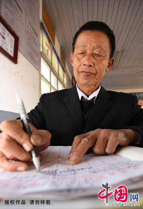 刘坤峰老人左眼患白内障，依然坚持多年备课的习惯。中国网图片库 胡卫国/摄