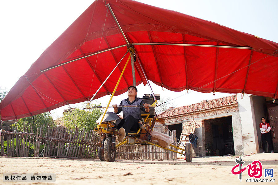 張海勇在自家院子裏測試飛機的運作情況。受場地限制，飛機無法飛離地面，然而就是在這個普通的農家小院裏，農民青年張海勇製造出了一架三角翼動力飛機。中國網圖片庫 聞舞/攝