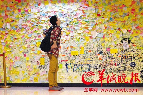 ▲2013年“光棍节”来临，广州的单身男女们在千方百计寻找自己的叧一半。图为在广州某商场内，这位男生在真情留言墙上寻找着什么？