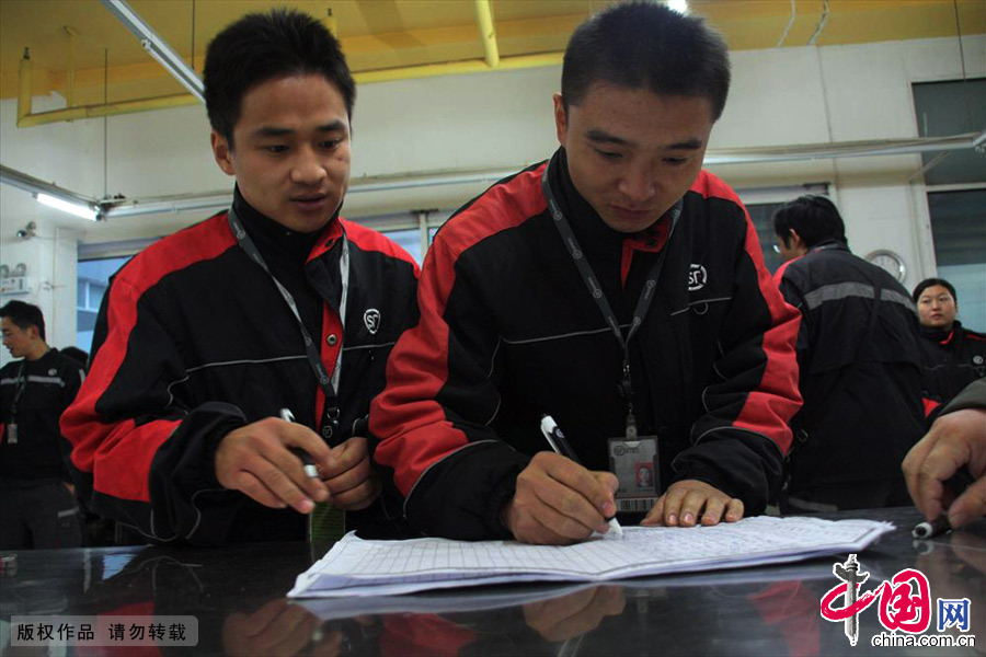 2013年11月11日清晨，位于山东济南历下区配送点，两名工作人员在签字记录考勤情况。