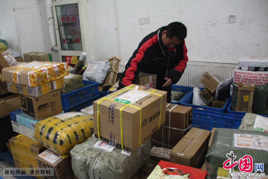 2013年11月11日，济南配送点工作人员分拣堆积如山的快递物品。