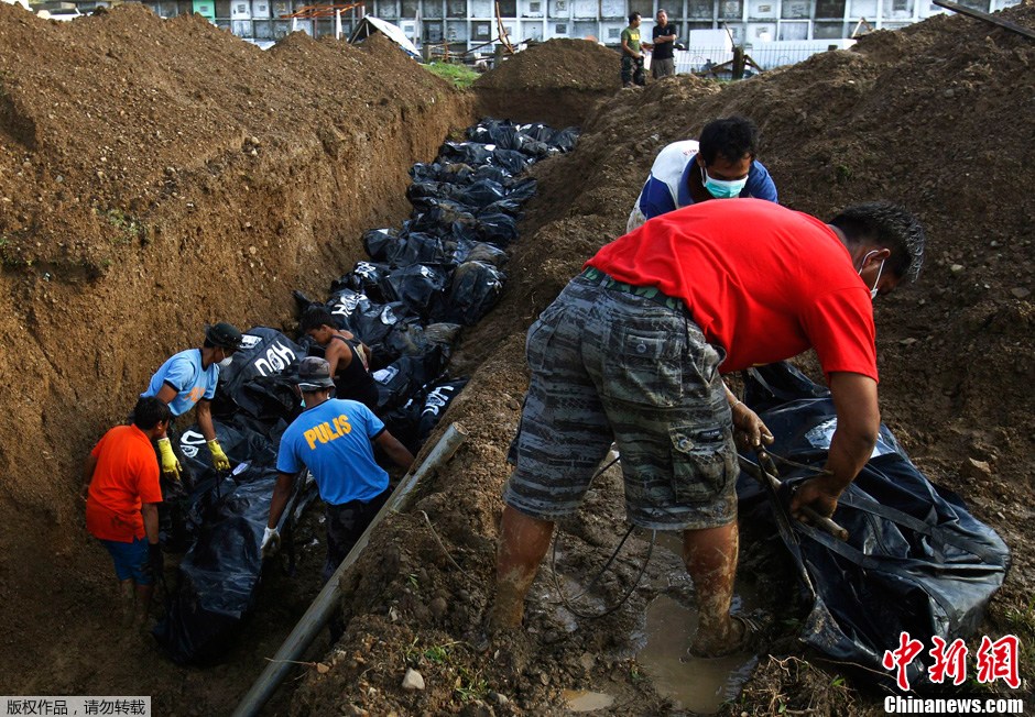 11月14日，菲律賓萊特省首府塔克洛班市，工人將颱風中的遇難者屍體集中挖坑埋葬。據菲律賓社會福利部提供的數據，強颱風“海燕”侵襲菲律賓造成的遇難人數是4460人，另有92萬人流離失所，災民人數總計達1180萬人。