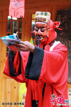 一名傩戏传承人戴着傩面具正在表演傩堂戏。这些上演的戏剧均有本所依，剧本有的取材于神话传说，有的取材于历史故事，有的取材于现实生活。中国网图片库 陈晓岚/摄