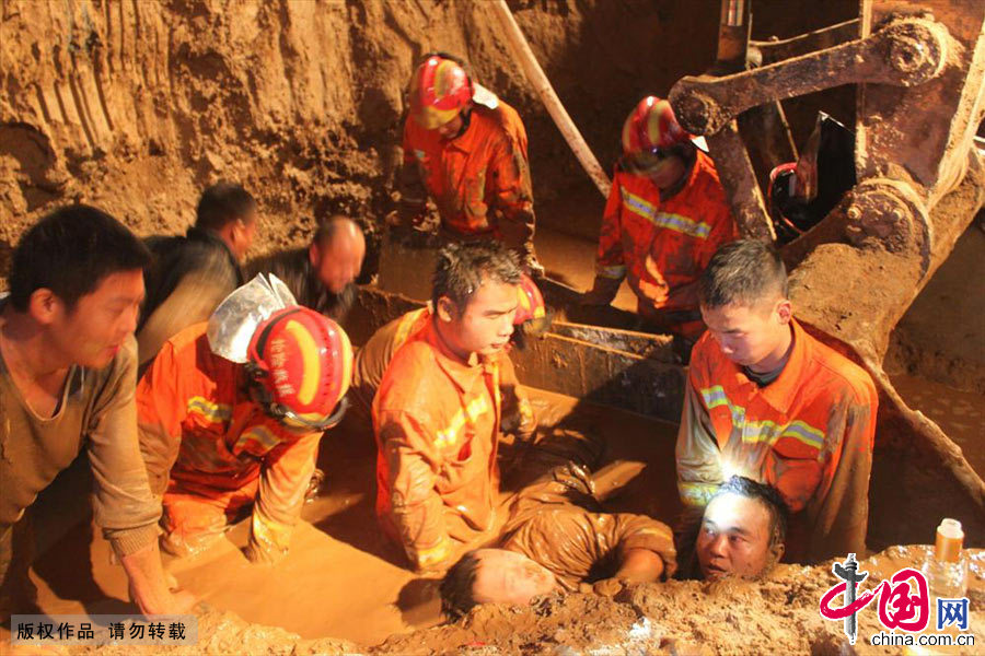 2013年11月19日晚，湖北十堰市消防官兵在救援现场施救该名被埋压工人。中国网图片库 李斌摄
