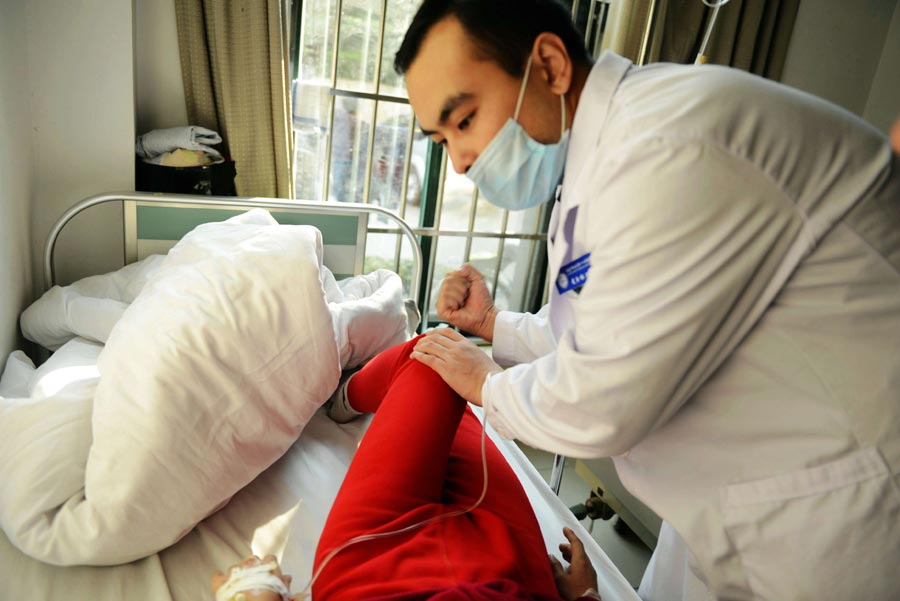 2013年11月22日，山东青岛开发区第一人民医院医生在检查一位受伤人员。图片来源： 中国网图片库 