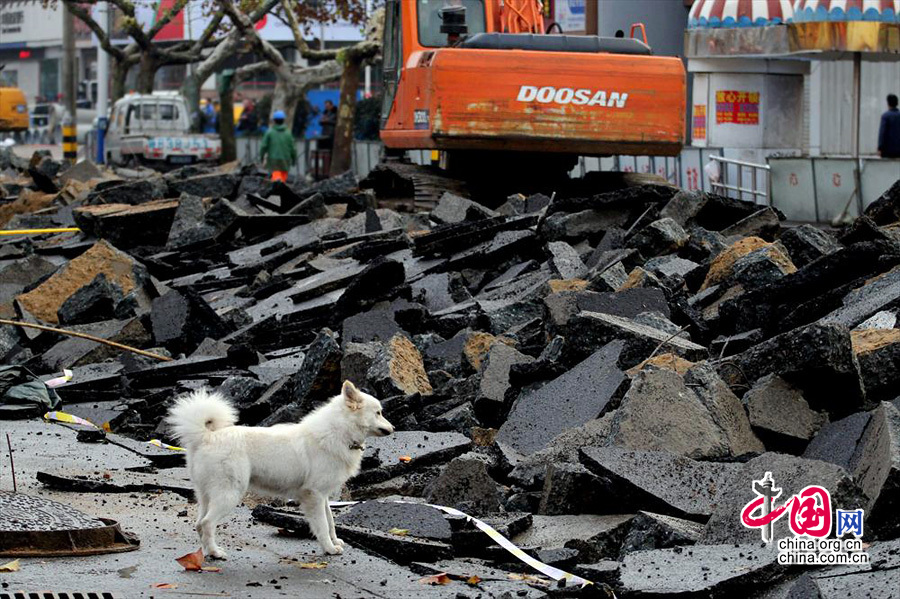 2013年11月24日，青岛漏油燃爆事故现场，挖掘机在破碎隆起的路面。22日中石化黄潍输油管线一输油管道发生破裂并起火燃爆。