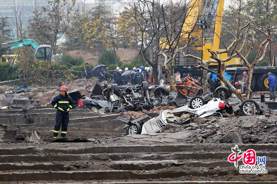 2013年11月24日，在燃爆事故最严重的区域，一名消防队员在查看现场。22日中石化黄潍输油管线一输油管道发生破裂并起火燃爆。