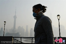 12月2日，一名戴口罩的游客在经过上海外滩观光平台。中国网图片库 赖鑫琳摄