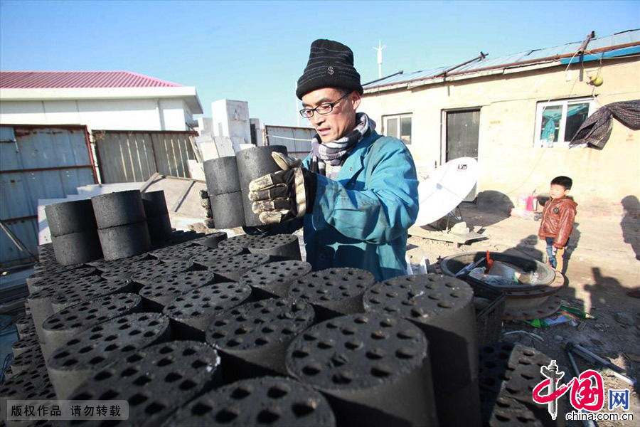 工曹大哥到了目的地正在把蜂窝煤卸载指定位置。中国网图片库 供图