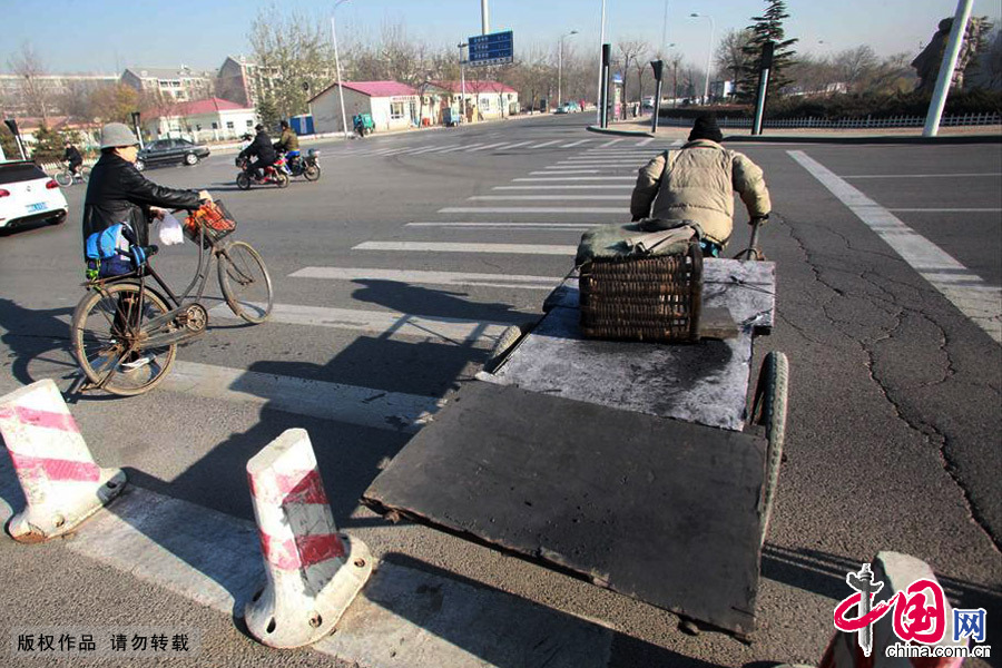 曹大哥完成一次任务拉着送煤车穿过城市马路，回去装车后奔向下一个目的地。中国网图片库 供图