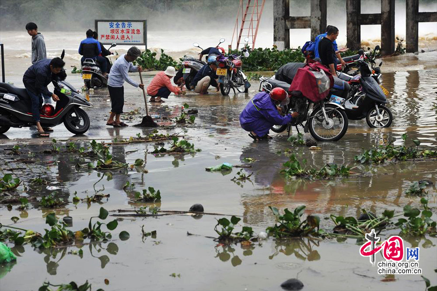 海南隆冬现罕见强降雨[组图]图为2013年12月15日，海南琼海， 市民借助暴涨的河水在万泉河边洗车