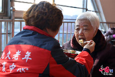 12月13日，刘彤在给83岁的患有阿尔茨海默病的袁秀兰喂饭。(中国网图片库 封疆江摄影）