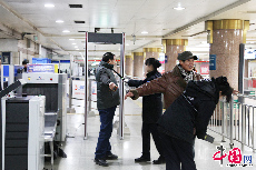 2013年12月16日，北京天安门西站地铁站内两名安检员对乘客进行安检。中国网记者 李佳摄影