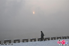 2013年12月17日，吉林省吉林市，行人在大霧籠罩的松花江畔行走。中國網圖片庫 王明銘  