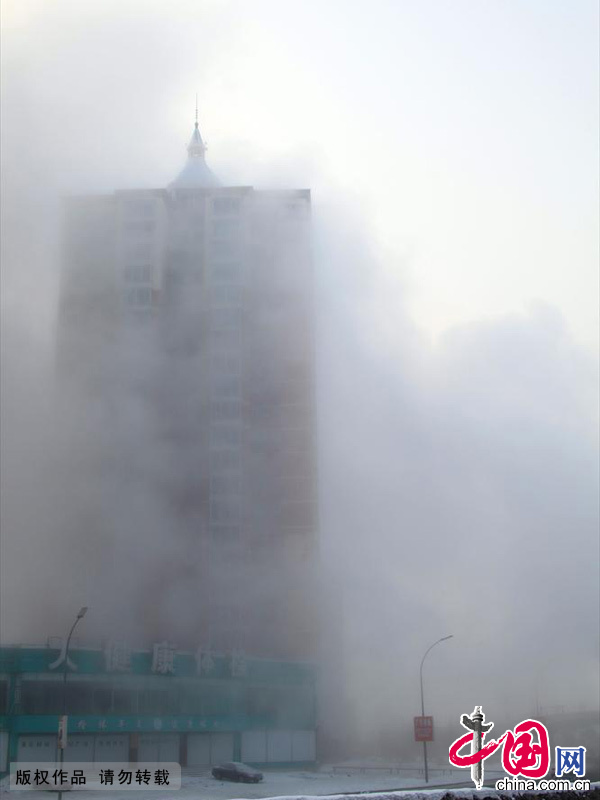 2013年12月17日，吉林省吉林市被大雾笼罩，城市建筑时隐时现，市民和车辆在雾霾中前行。