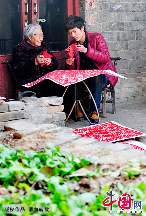创作之余，畅杨杨经常会到村镇民间剪纸老艺人家中“取经”，每次登门拜访都让他有不小的收获。中国网图片库 黄政伟/摄