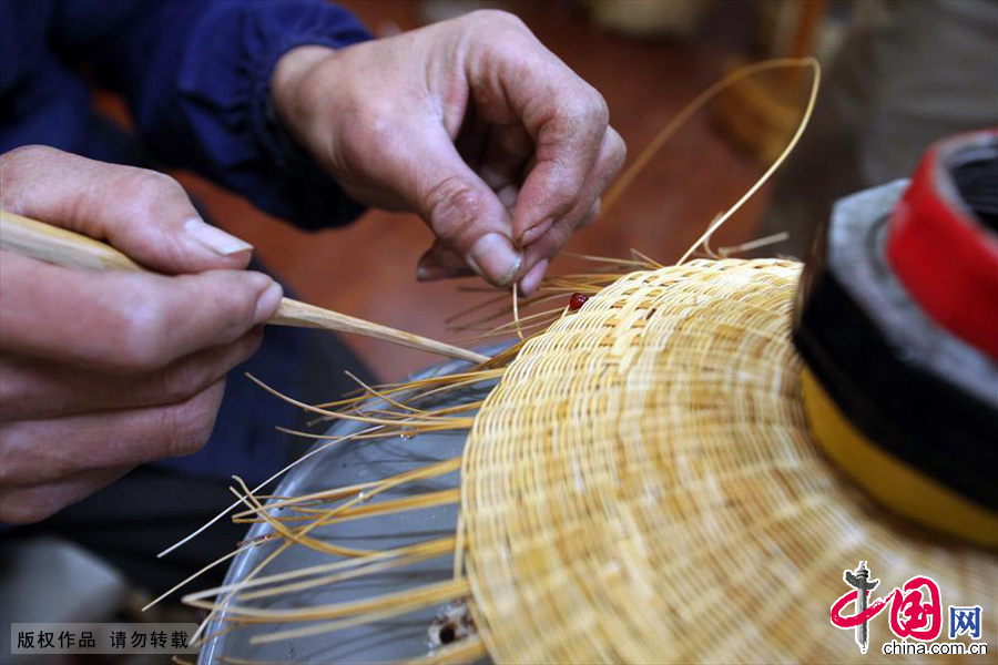 一顶普通的平纹草帽，编织完成只需一天多的时间，带有简易粗线条图案的，需三天时间。中国网图片库 吕斌/摄