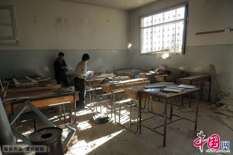 当地时间2013年12月22日，叙利亚阿勒颇郊区，孩子们在教室寻找自己的物品 图片作者:MOHAMMED AL-KHATIEB/CFP