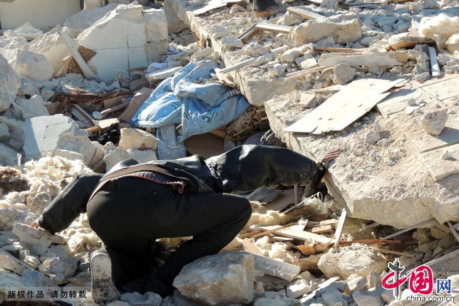 当地时间2013年12月22日，叙利亚阿勒颇郊区，人们在废墟中搜索幸存者图片作者:MOHAMMED AL-KHATIEB/CFP