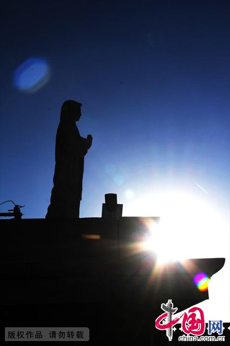 夕阳辉映下的圣母塑像。中国网图片库 范根林/摄
