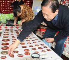 12月24日，收藏家曾继红在家中同来参观的市民一道布展。中国网图片库 王将 摄