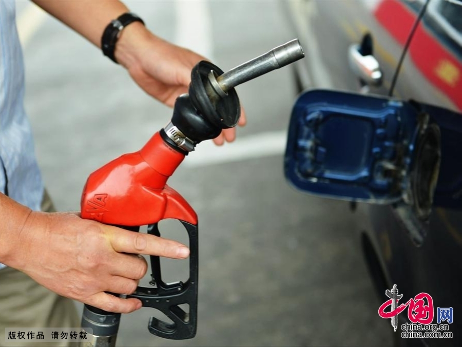 2013年09月29日，浙江省杭州市，杭州一加油站的工作人員在為汽車加油。