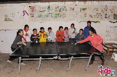 云南连心社区共有2个儿童活动中心和1个青少年活动中心。每月会开展类似摄影、戏剧、小志愿者等专题小组，参与儿童超过了300人。图为儿童活动中心的孩子们在打乒乓球。 中国网记者 佟静 摄 