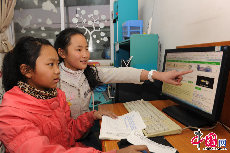 在连心社区青少年活动中心，孩子们可以看漫画、童话故事，学习使用电脑、互联网，在这里，孩子们也可以打乒乓球、下棋，还可以参加老师们准备的各种兴趣小组。图为孩子们在学习使用电脑。 中国网记者 佟静 摄 