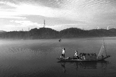 老唐在船頭玩著自己的草帽，他們夫婦每天在這片濕地進行表演，讓遊客和攝影人捕捉精彩的畫面。 中國網圖片庫 鄭躍芳 攝