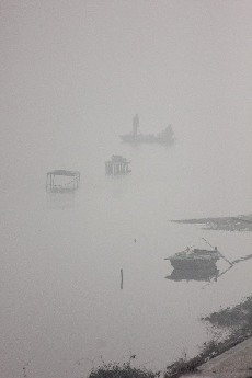 2014年1月6日，在沙颍河河南省周口市区段，渔民在雾中捕鱼。中国网图片库 金月全摄