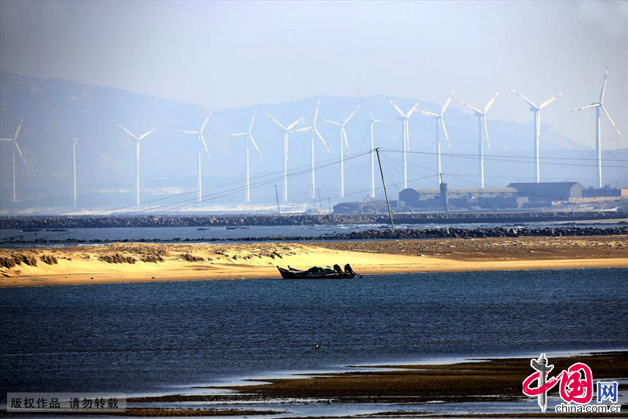 蓝色平静的水面，成排的风力发电在嗡嗡作响。中国网图片库 成卫东/摄
