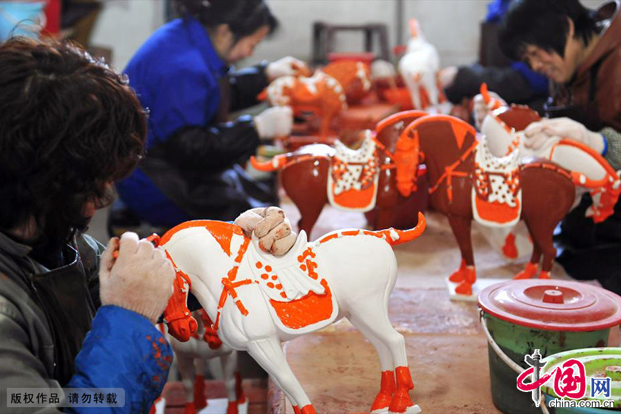 河南省孟津县一名工人正在对仿唐三彩工艺半成品上釉。中国网图片库 黄政伟/摄