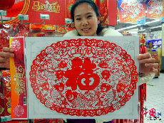 1月7日，一位市民在蘇州一家超市展示剛選購的喜慶剪紙飾品。