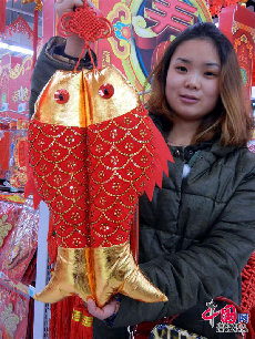 1月7日，一位市民在蘇州一家超市展示剛選購的布藝“喜慶魚”挂件。