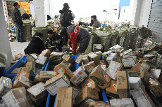 2014年01月12日，浙江省临安市一家快递公司的工作人员在分拣包裹。