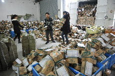 2014年01月12日，浙江省临安市一家快递公司的工作人员在分拣包裹。中国网图片库 胡剑欢摄