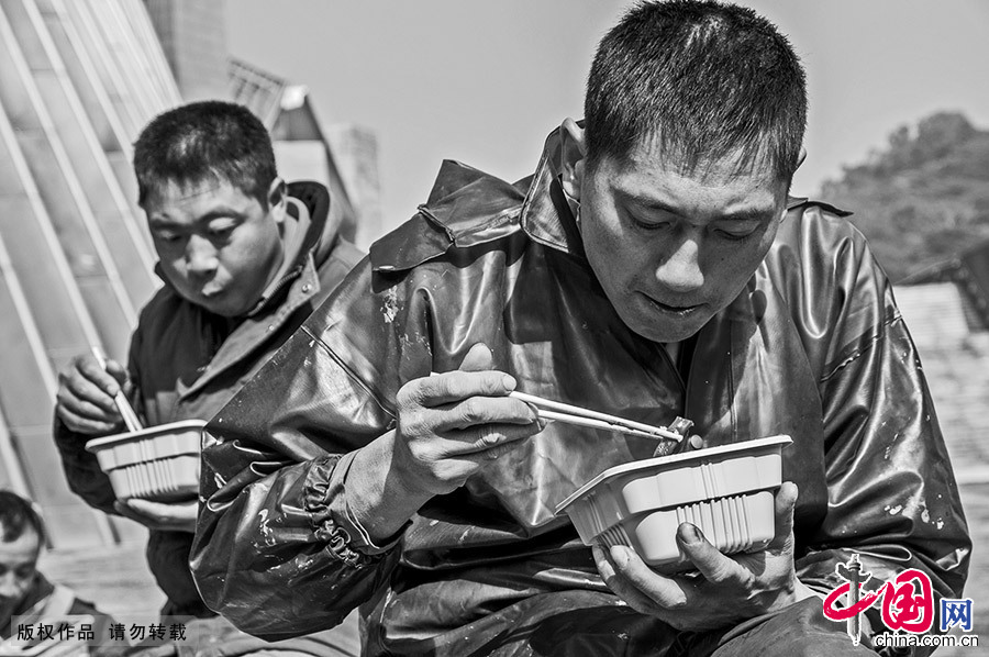到中午时分，工人们就近吃一点简单的盒饭，一般都没有午休时间。中国网图片库 邓飞/摄 