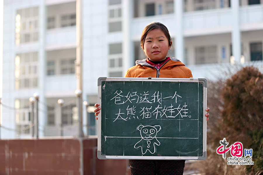 2013年1月14日，安徽省蚌埠市固镇县清凉小学，六年级学生在寒假即将来临前，展示寒冬里的假期心愿。图为张情情，寒假愿望是爸妈送我一个大熊猫布娃娃。
