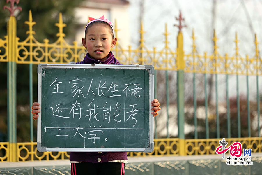 2013年1月14日，安徽省蚌埠市固镇县清凉小学，六年级学生在寒假即将来临前，展示寒冬里的假期心愿。图为邱雅洁，寒假愿望是全家人长生不老，还有我能考上大学。