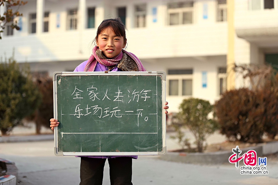 2013年1月14日，安徽省蚌埠市固鎮縣清涼小學，六年級學生在寒假即將來臨前，展示寒冬裏的假期心願。圖為蔡麗佳，寒假願望是全家人去遊樂場玩一下。